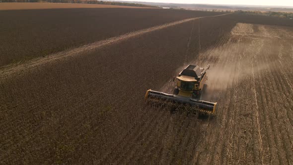 Slow Motion Aerial View of Combine Harvester Working on a Field alt