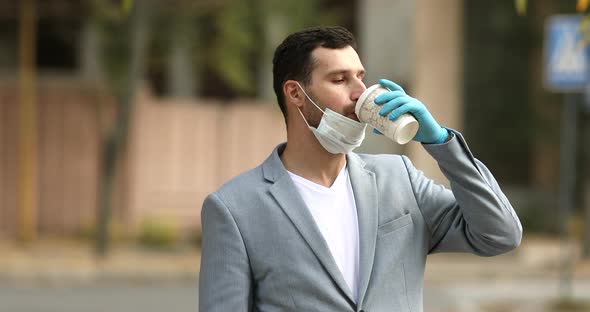 Man in protective medical mask drinking coffee.
