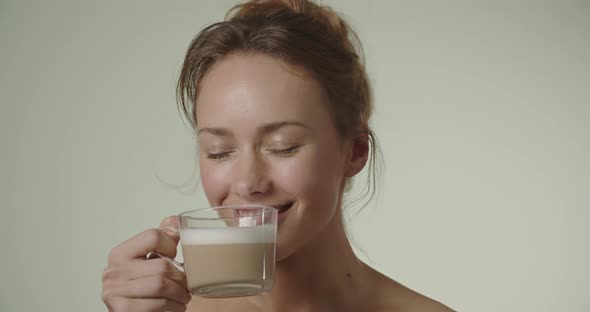 Young Woman Smiling And Taking A Drink Of Coffee