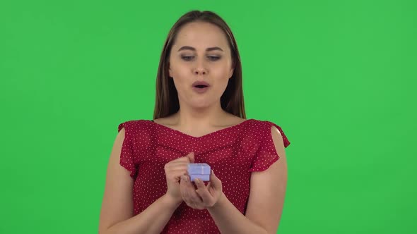 Portrait of Tender Girl Is Opening a Small Box with a Surprise and Is Very Rejoicing, Saying Yes alt