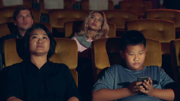 The Boy is Playing with Mobile Phone alt