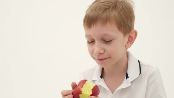 Little boy missing some teeth eats red apple alt