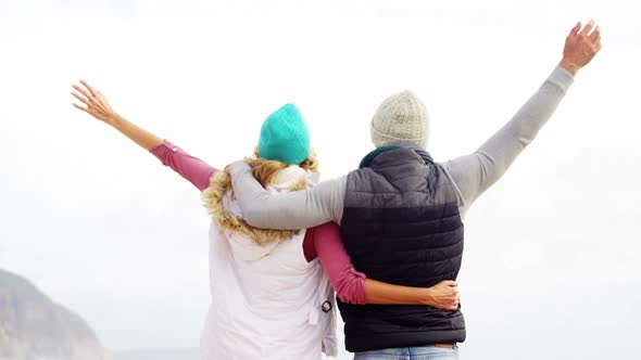 Couple standing with arms outstretched alt