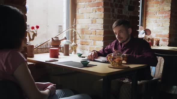 Young Business Couple Finished Their Meeting in Chinese Tea Cafe and Leave alt
