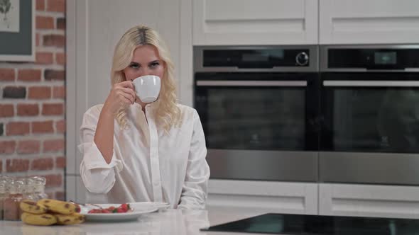 Portrait of Satisfied Woman Drinking Tea on Kitchen