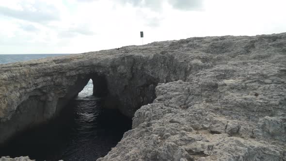 Coral Lagoon Cave with Visible Entrance to Sea on a Windy Day in Malta on Winter alt