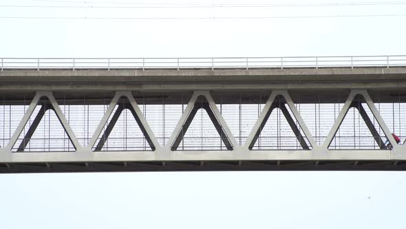 Two bike riding men driving from the right to the left over a steel construction bridge in the sky, alt