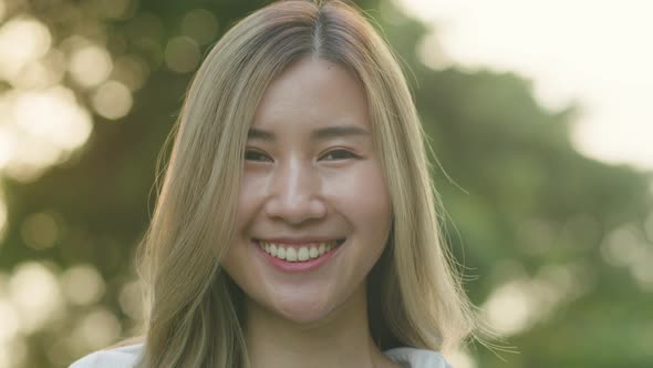 Smiling Asian female looking up at the camera.