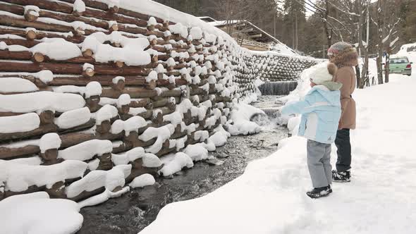 Two Girls Looking at Winter Waterfall Landscape