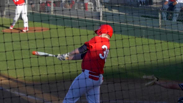A baseball player batter makes a play at a game. alt