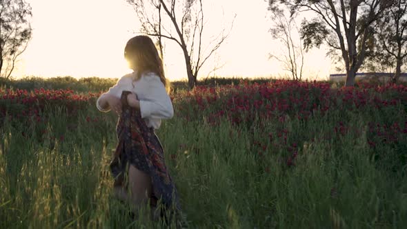 Girl dancing happily in a blooming field