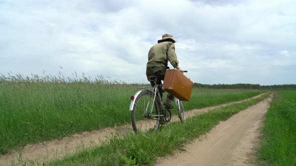 Man on Bicyle Grabbing Suitcase with Treasures That He Found on the Country Road, Find Concept