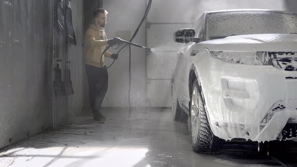 Car Washing at Selfservice Station Hose for Spraying Soap Foam in a Garage