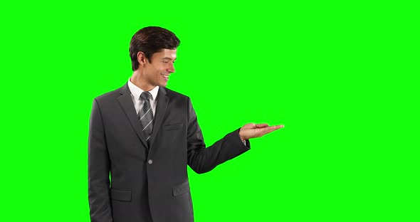 Side view of Caucasian man holding his hand for copy space with green screen alt