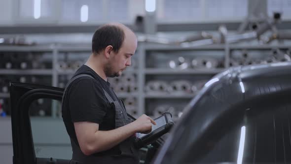 Mechanic Using A Digital Tablet to Search for Approval and Diagnose Car Breakdowns alt