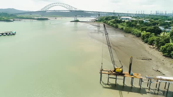 Drone footage of a dock in construction near Panama canal main bridge. alt
