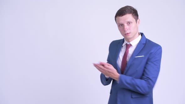 Happy Young Businessman Snapping Fingers and Showing Something alt