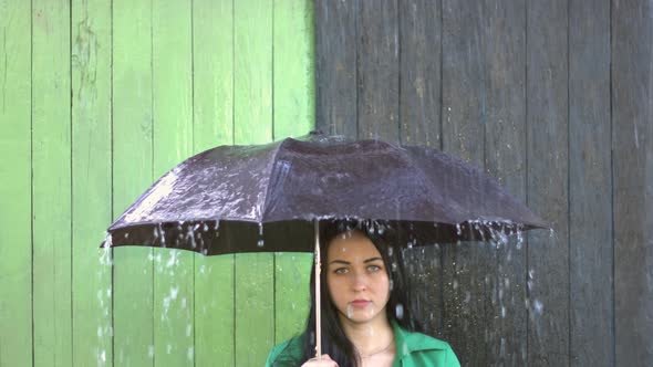 Heavy Rain pours on Girl Sheltered under Umbrella