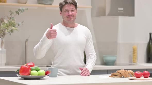 Man Showing Thumbs Up While Standing in Kitchen alt