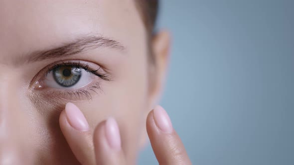 Close Up View of Beautiful Young Woman Touching Face Half and Looking to Camera  alt