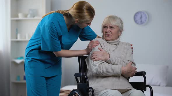 Kind Nurse Covering With Blanket Handicapped Old Woman Shivering From Cold alt