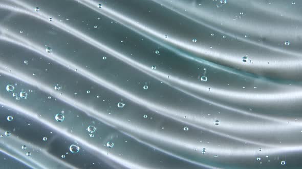 Motion Rotation of the Liquid Cream Gel Blue Transparent Cosmetic Texture with Bubbles alt