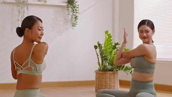 Calm of Attractive two Asian woman friend practice yoga Eagle or Garudasana pose to stretching and m alt