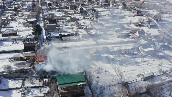 Aerial View of Firefighters Extinguishing a House in the Village alt