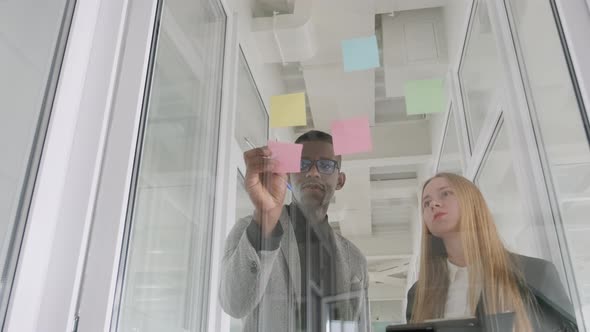 African Black Man and Caucasian European Young Woman Working Together Partners