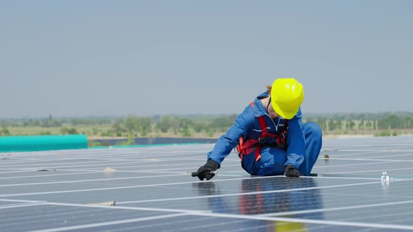 female worker attaching solar panels to the roof of the factory