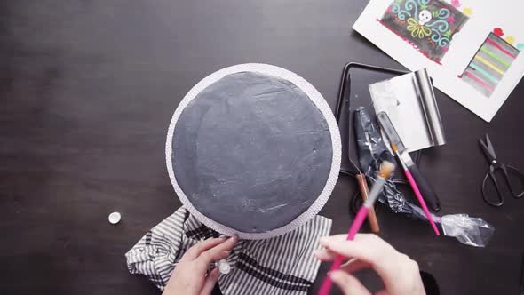 Time lapse. Step by step. Flat lay. Baker applying glittery dust with brush to a black multilayer ca alt