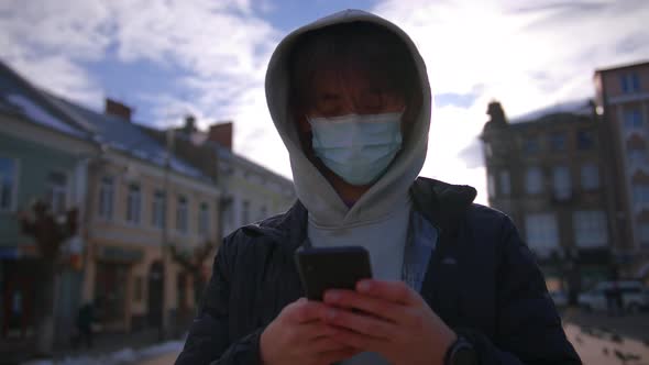 Young Man Wearing Protective Face Mask Use Phone COVID19 Coronavirus Infection Pandemic Disease alt