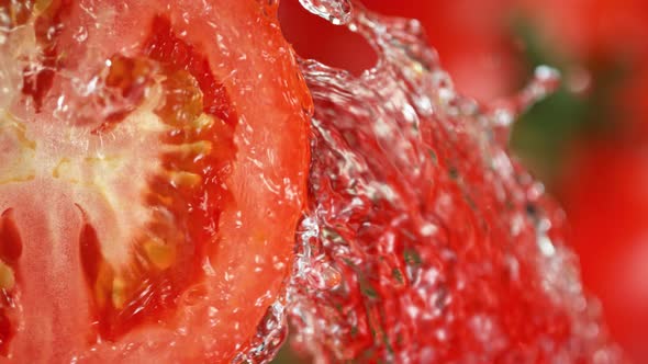 Super Slow Motion Shot of Splashing Water on Rotating Tomato Slice at 1000Fps. alt