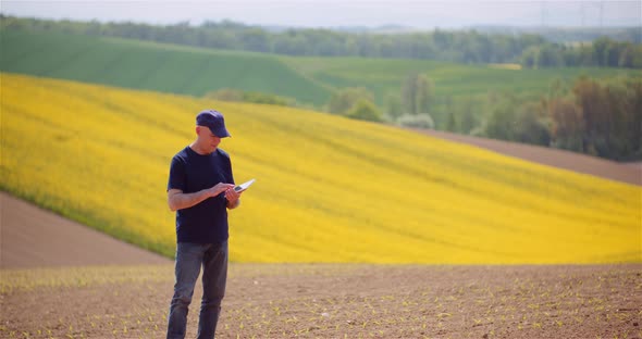 Successful Modern Farmer Smoking His Pipe On Field Wile Examining Crops Agriculture. alt