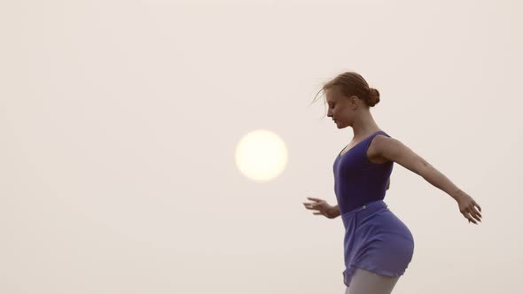 Female Ballerina is Engaged in Outdoor on Background of Sunset Rehearsing Dance Front View alt