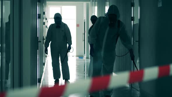 Male Disinfectors Work in Restricted Area, Spraying. alt