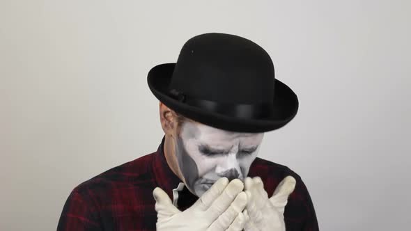 A Horrible Man in Clown Makeup Sneezes Heavily. The Scary Clown Looks at the Camera and Sneezes