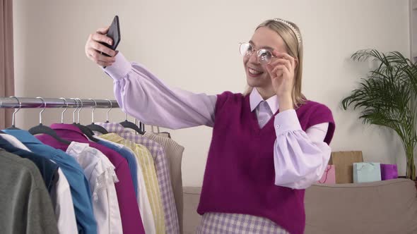 A Female with a Smartphone in Her Hands Tries on Glasses Online Via Video Link