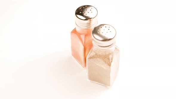 Two Glass Pepperjars with Stainless Steel Cap Full of Grounded Black Peppercorns and Red Paprika