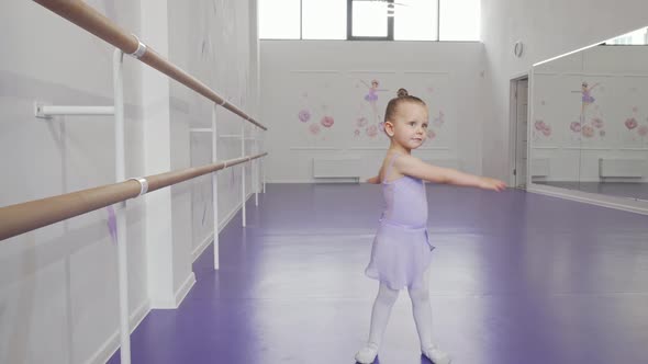 Cute Little Ballerina in Leotard Whirling in Dance at Ballet School alt