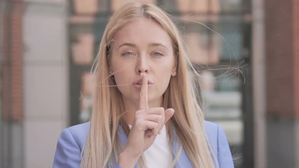 Silence Please, Finger on Lips by Young Businesswoman alt