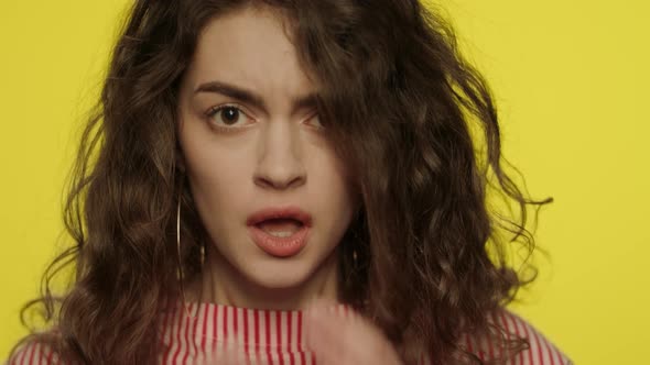 Afraid Woman Face with Open Mouth Touching Face with Hands on Yellow Background alt