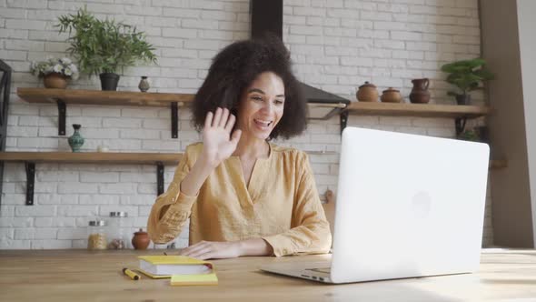 Happy African American Young Woman Looking at Computer Screen, Waving Hello. Pleasant Attractive alt