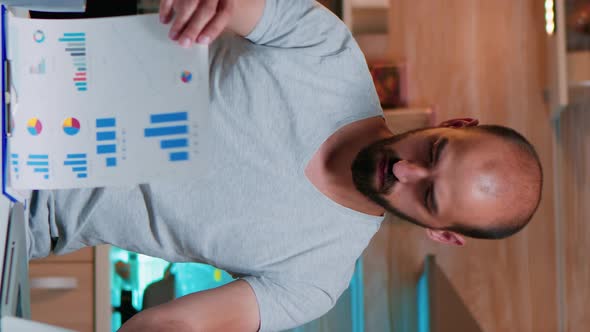 Vertical Video Remote Employee Checking Graphics From Clipboard Using Laptop alt