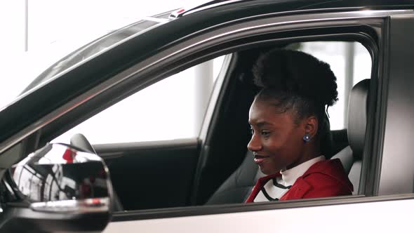 African American Woman Choosing a Car in a Salon and Checking the Salon alt