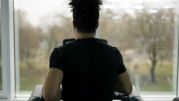 Man Trains in Gym Doing Cardio Workout on Treadmill Back View alt