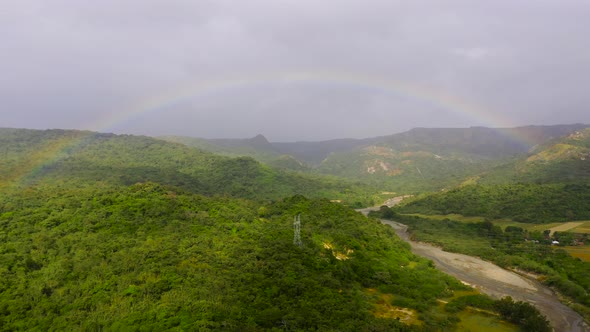 Rainbow Over the River in the Highlands. Mountains on Luzon Island, Philippines alt