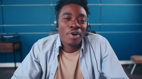 Happy African American Man with Headset Talking By Webcam Says Hello alt