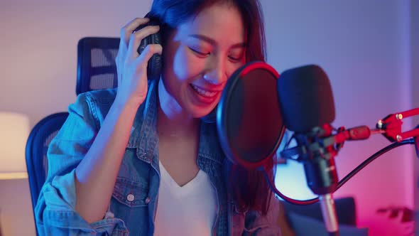 Happy asia girl blogger play synthesizer keyboard wear headphone and record music with sound.