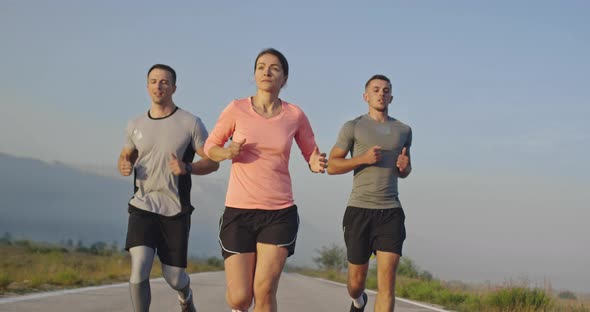 Multiethnic Group of Athletes Running Together on a Panoramic Countryside Road alt